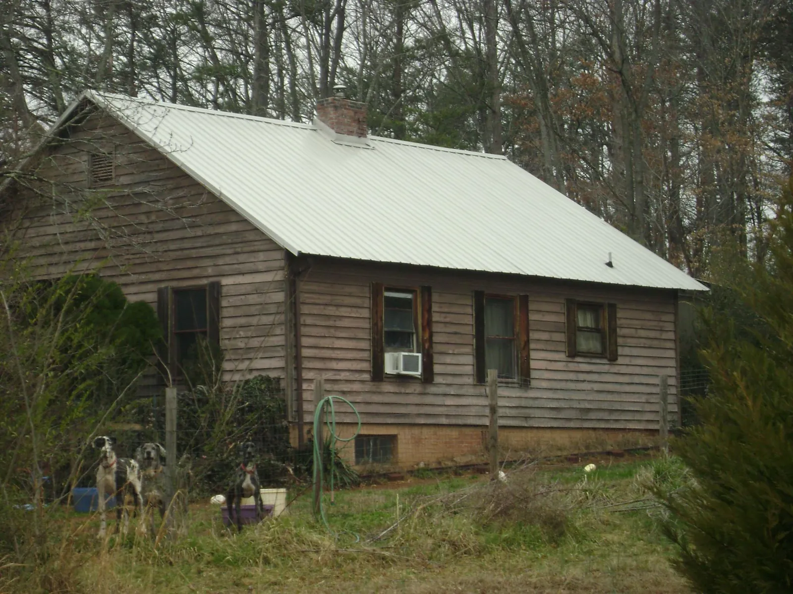 White metal roof on an old wood sided farmhouse, from a Metal Roof Installation job in Laurens